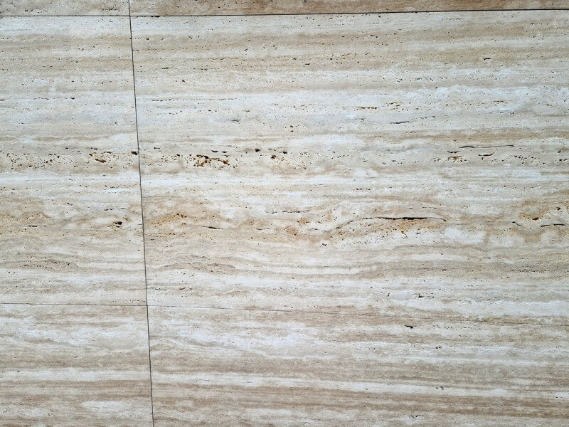 Unpolished travertine stone tiles in a bathroom setting.